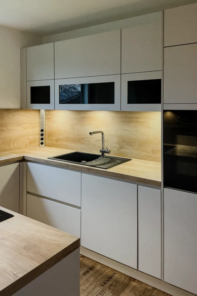 Moderne Küchenzeile mit Spülbecken, Armatur, Arbeitsplatte, Schubladen und Oberschränken.