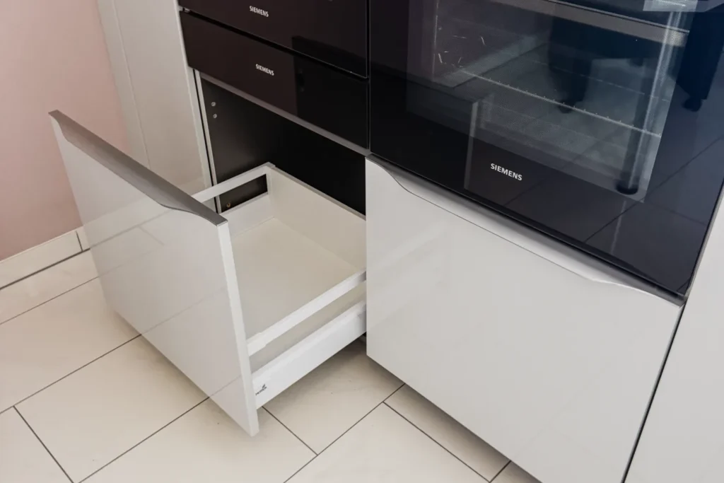 Küchen-Auszug mit weißem Rahmen vor Backofen mit Sichtfenster; Aufkleber „SIEMENS“.