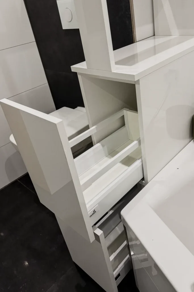 Ausziehbarer Schrank mit Schubfächern und Innenablage in einer weißen Küchenzeile.