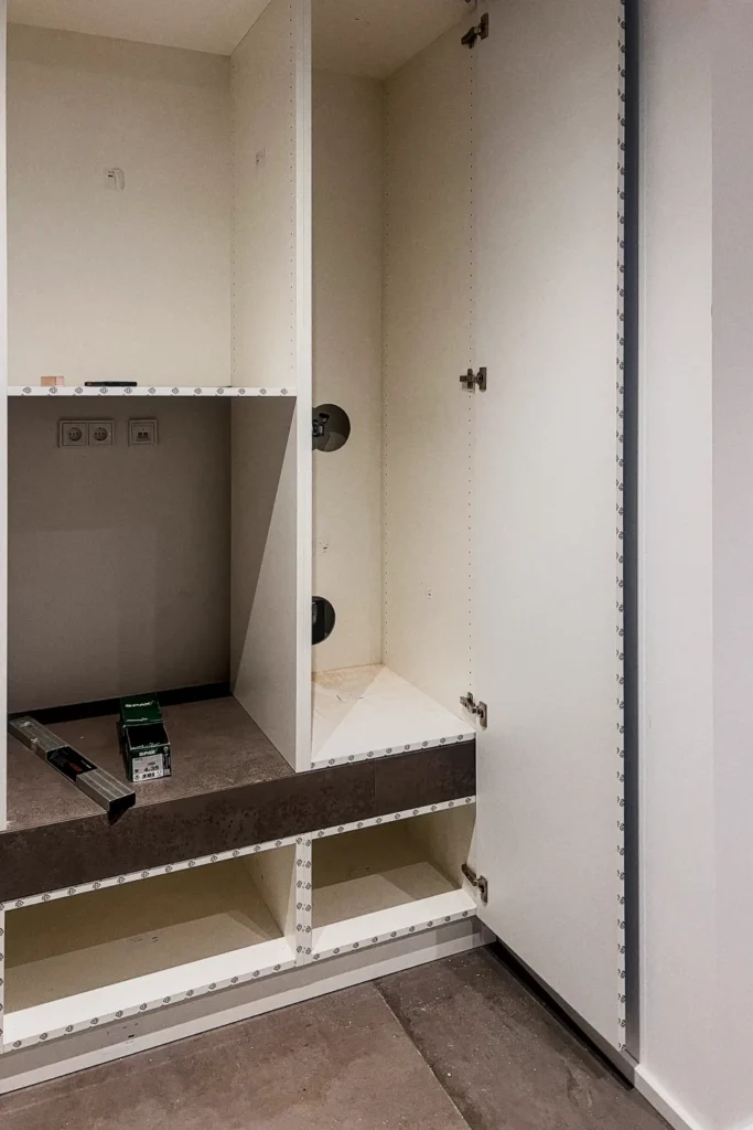 Küchenunterschrank mit offenen Türen, Einlegeböden und Steckdosen an der Seitenwand im Innenausbau
