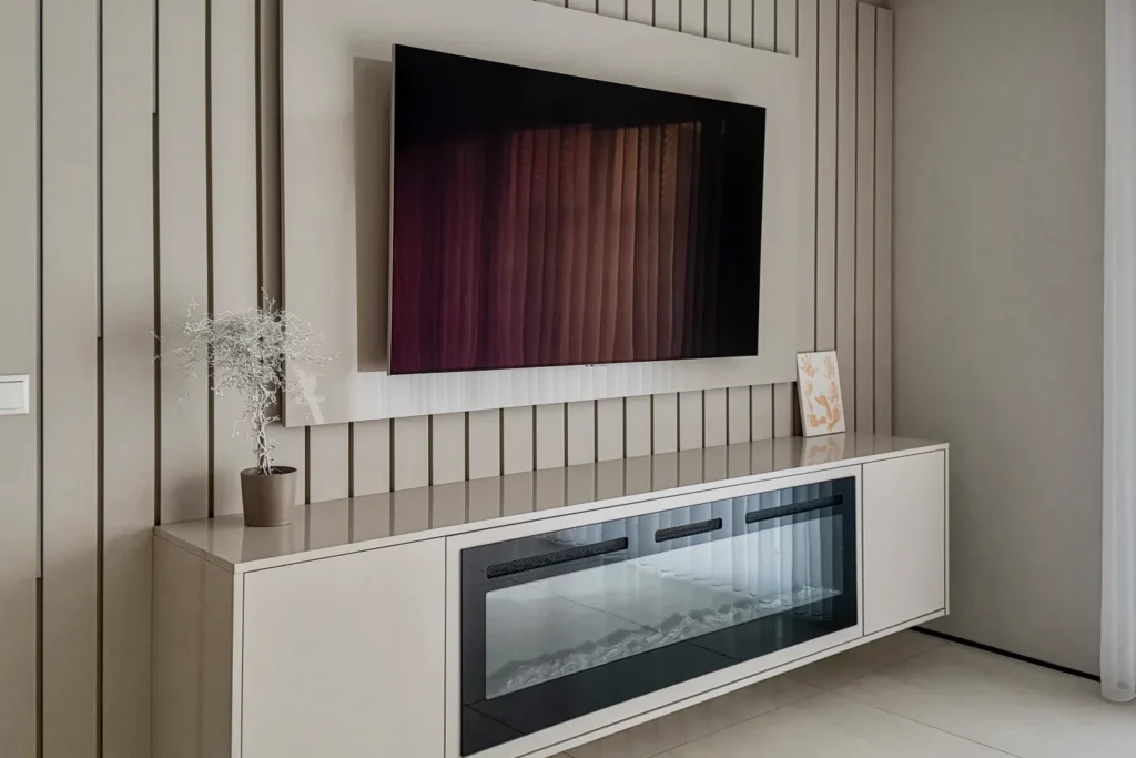 Weiße Einbauküche mit großem TV im Wandnischenschrank und Glastür des Backofens