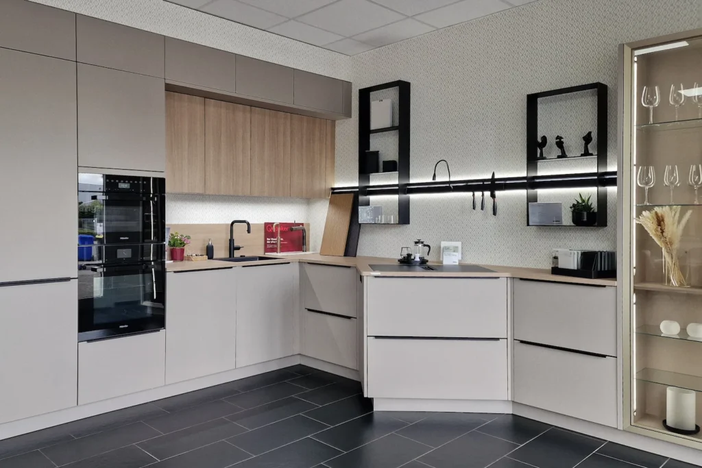 Moderne L-förmige Einbauküche mit Backofen, Kochfeld, Spüle, weißen Schränken und LED-Unterbau